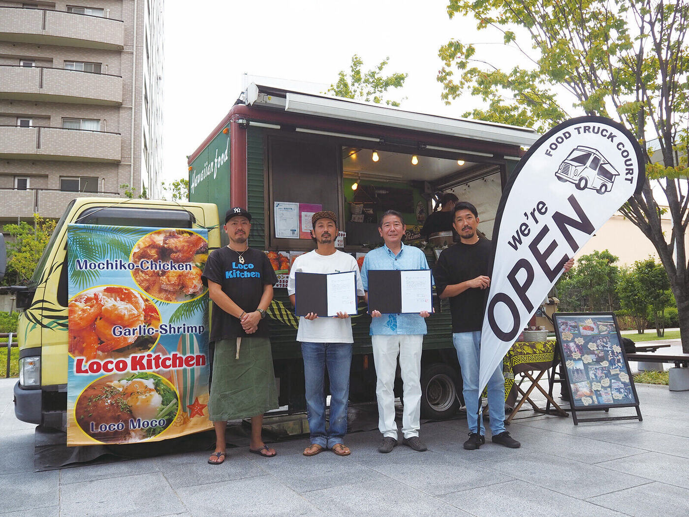 茅ヶ崎市との災害時協力協定 締結式。キッチンカーの前で協定書を掲げる協会メンバー
