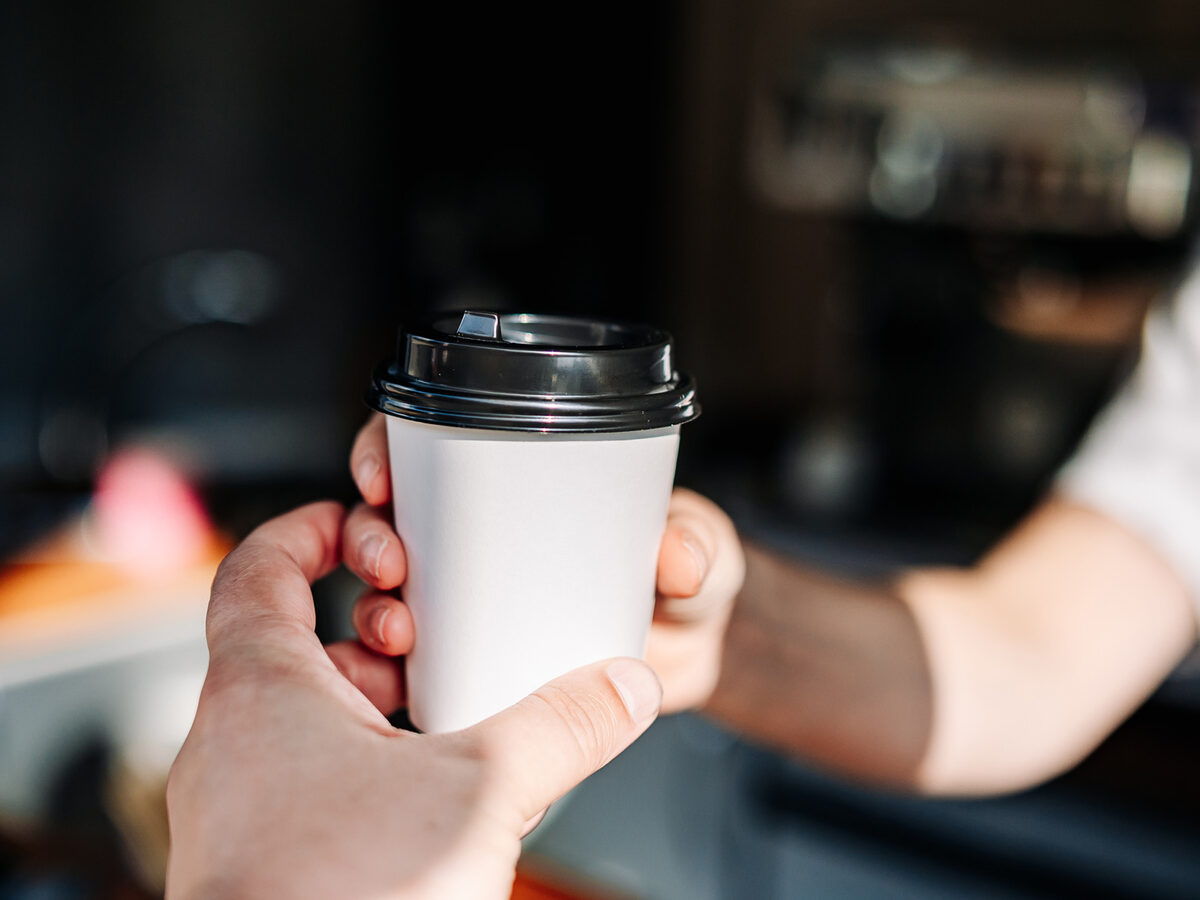 カウンター越しにコーヒーを手渡す様子